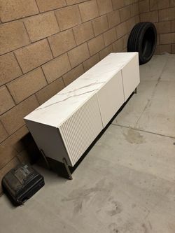 modern white fluted TV stand / media console with a marble-look top