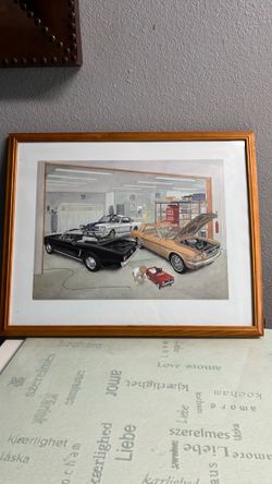 Framed picture of 3 cars in a garage with a little boy with his red car