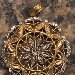 Circa 1985, a 31mm round 10k yellow Rolled gold filigree fashion medallion pendant.