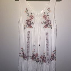 Chic white dress with vibrant floral embroidery. Features elegant designs in purple, pink, and yellow in a size Large