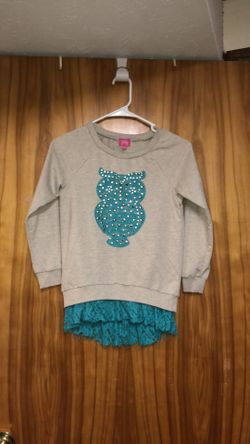 Kid’s size medium (10-12) shirt with a turquoise rhinestone owl and a lace bottom. Super adorable on!