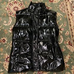 Black puffer metallic long vest with adjustable straps, zipper and buttons.