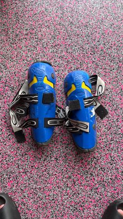 AXO motocross/dirt bike knee + shin guards (hard plastic shell with yellow padding inserts, dual adjustable Velcro straps, and left/right specific des
