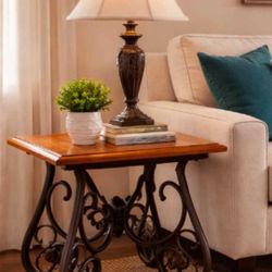 Sturdy set of two matching side tables featuring  wooden tops and decorative wrought iron