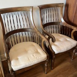 Pair of vintage wooden armchairs with lattice back and a yellow ikat-patterned upholstered seat cushion 