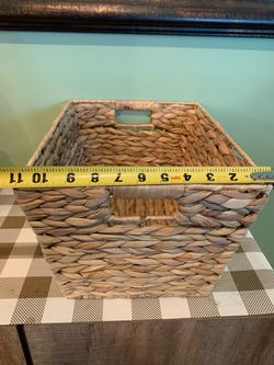 11x14 inch thick weaved basket on metal frame for storage, has 2 handle opening, wide weaved material, tapered rectangle shape