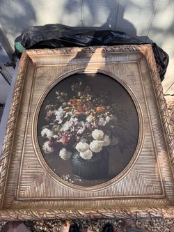 Oval floral still life oil painting in an ornate gilded frame.