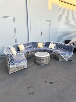 Curve patio set with navy blue cushions and center glass table