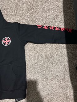 Black full-zip hoodie featuring red cross chest graphic and gothic-style print details.