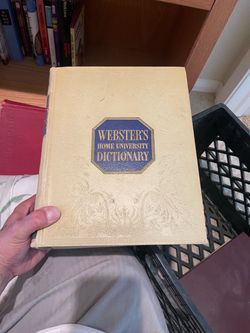 vintage copy of Webster's Home University Dictionary, featuring a cream or light yellow embossed cover with a blue octagonal