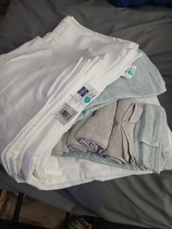 Brand new towel set, twin set of sheets, and laundry bag, and fluffy blankets.