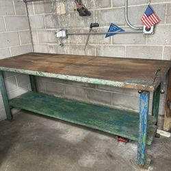 Vintage industrial workbench made of solid wood and metal, ideal for workshops or rustic decor. 