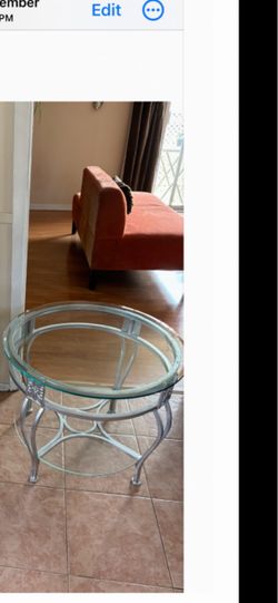 Beautiful round accent table featuring a beveled glass top and an elegant silver metal frame