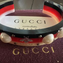 Gucci bracelet with faux pearls, silver-colored rivets and bee motif in white, red and navy blue. 