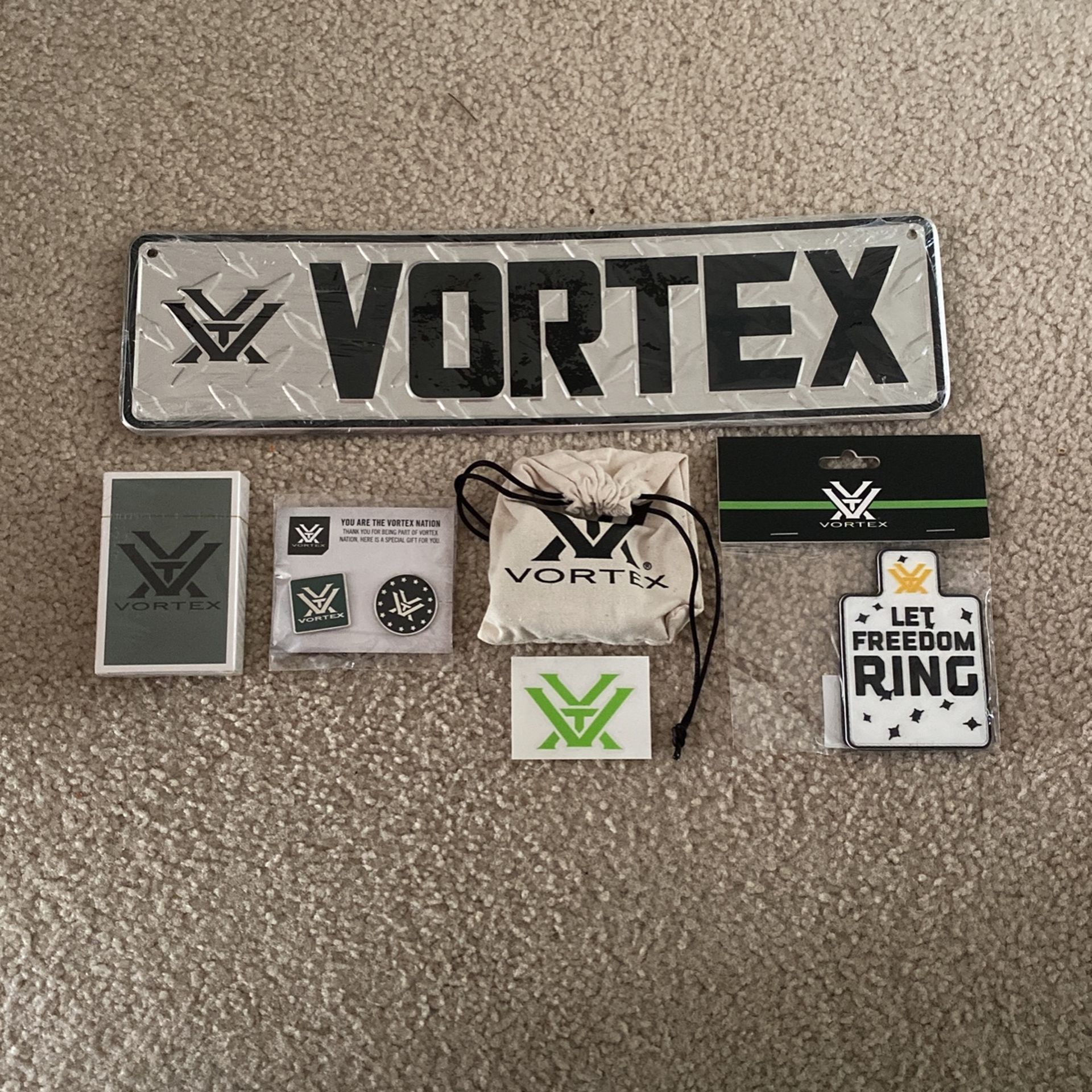 Brand new metal vortex sign, unopened playing cards, pins ,stickers ,dice and a Velcro patch