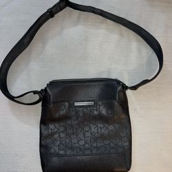 black Calvin Klein shoulder bag with an embossed monogram logo pattern