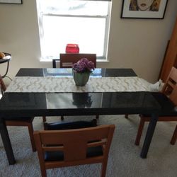 Black solid granite table with chairs