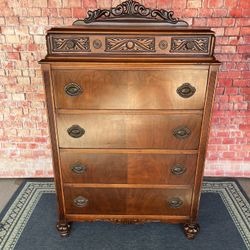 Antique highboy dresser with ornate carvings and five drawers