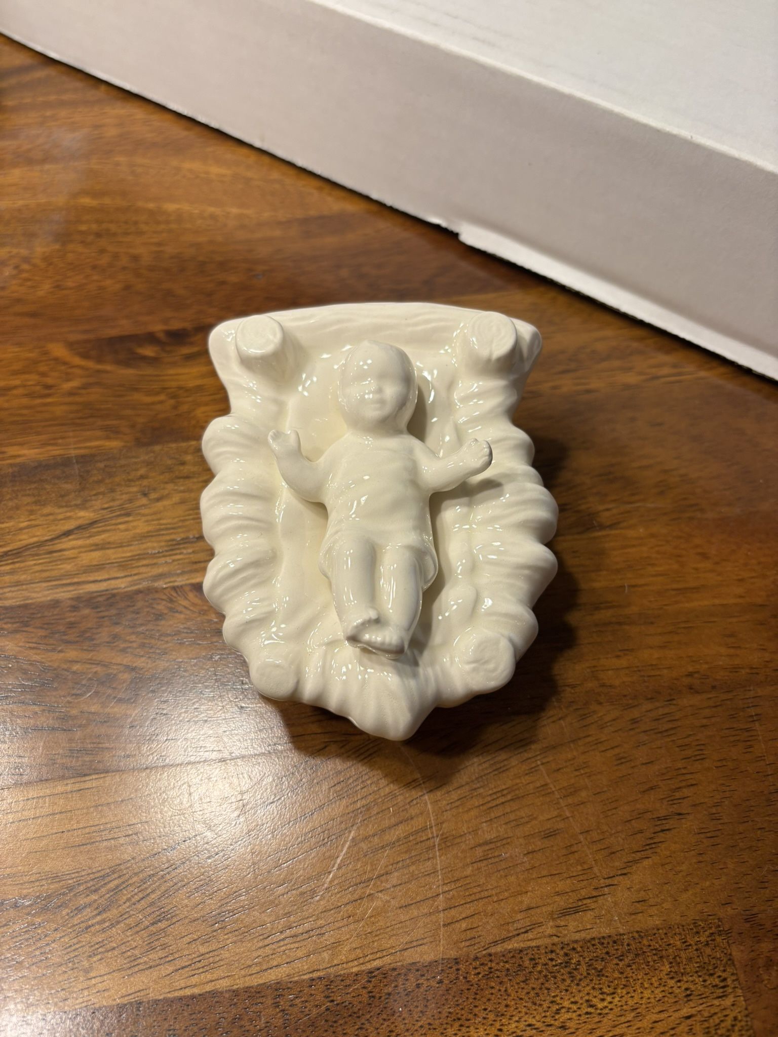 white porcelain figurine of the Baby Jesus in a manger