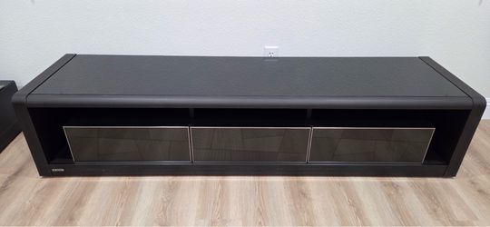 A modern TV stand with three drawers and an open shelf.