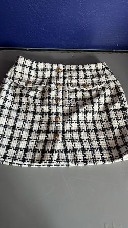 Better be black and white checkered skirt  with gold color buttons