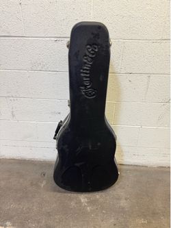 This is a Martin & Co. hard guitar case featuring a molded, embossed logo.