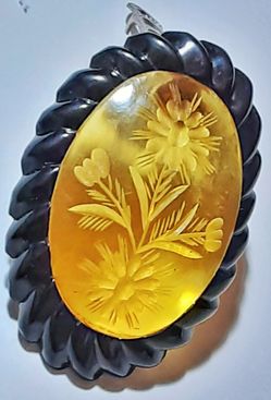 Art deco carved apple juice bakelite dress clip with black bakelite faux rope border
