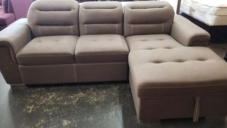Tan color sofa chaise sectional with a pullout bed