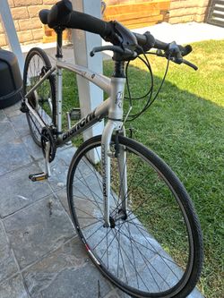 Silver Bianchi Camaleonte Sport 1 hybrid bicycle has an aluminum frame and fork. This bike features Shimano shifters and a triple crankset. The chain 