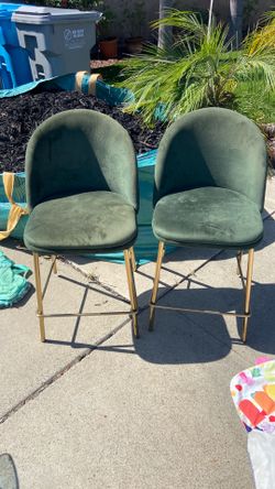 Two bar height velvet dark green chairs with gold legs