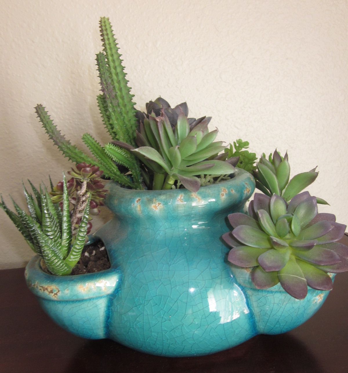 Teal ceramic vase with artificial succulents