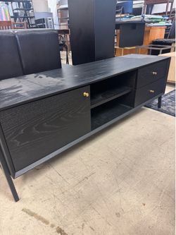Black TV stand features two drawers and open shelving accented with gold-toned hardware - 57” x 16” x 20”