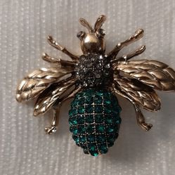 Bee-shaped brooch with gold tone and green detailing.