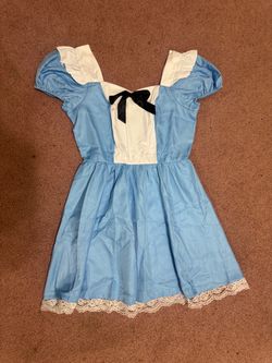 New s blue and white costume dress with a black bow accent. Soft puff sleeves and a full skirt create a playful silhouette. Lace trim adds a delicate