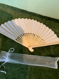 14 inch wide hand fan w/carved wood accents, folds into a gift bag with ribbon.