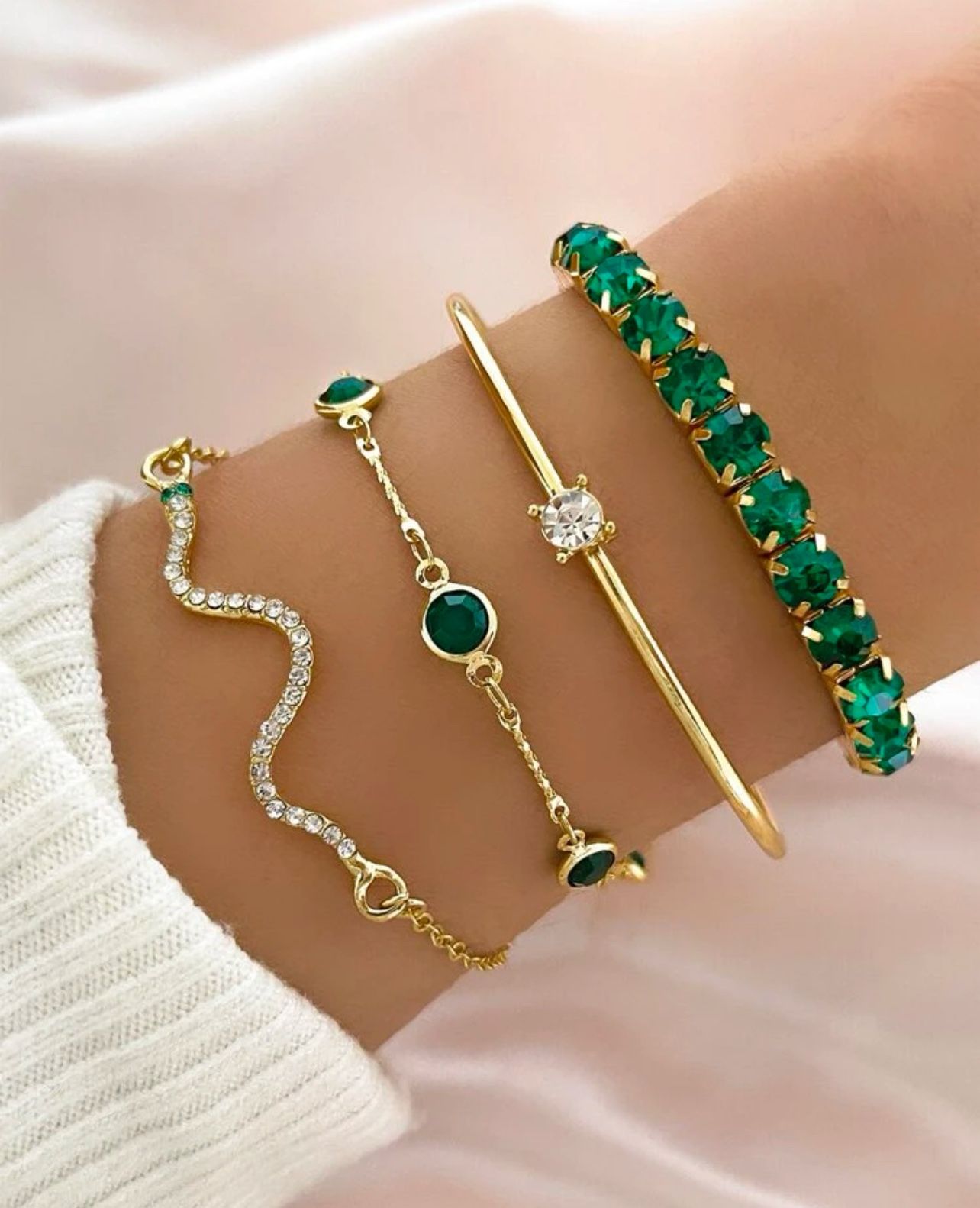 Set of 4 gold and emerald green bracelets.