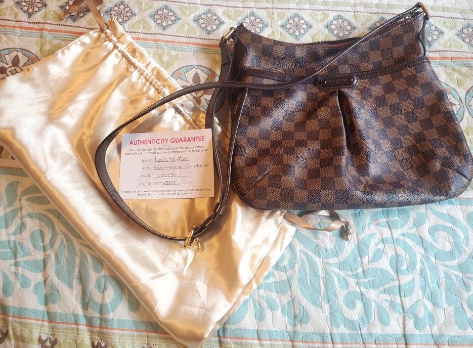 This is an authentic LOUIS VUITTON Damier Ebene Bloomsbury PM.  