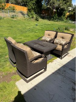 Outdoor lounging chairs with table that has gas fire burner.