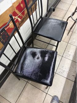 Black metal dining chairs with padded vinyl seats