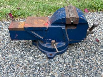 blue cast-iron utility bench vise with a swivel base and a built-in anvil.