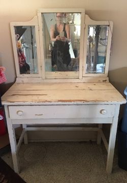 Antique white distressed vanity table with attached swivel beveled mirror
