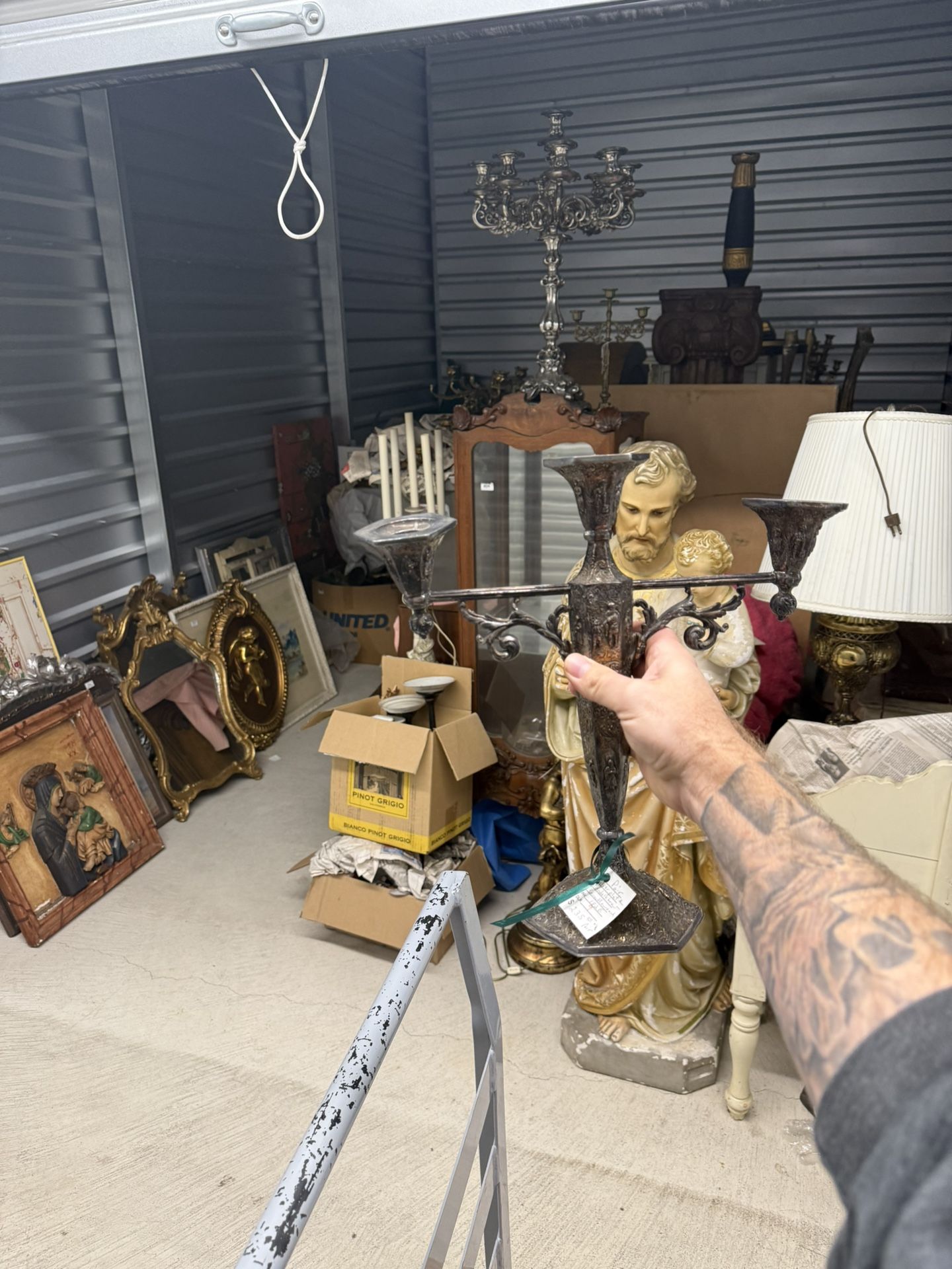 Ornate silver-plated candelabras with relief carvings and three candle holders.