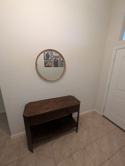 Elegant wooden console table with a round mirror.