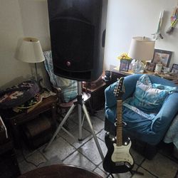A Silvertone electric guitar and Harbinger VaRi V2115 powered loudspeaker.