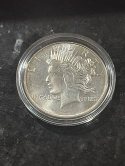 1 Troy oz .999 silver round with peace dollar design with a little bit of toning.