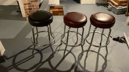 Three barstools two maroon one black