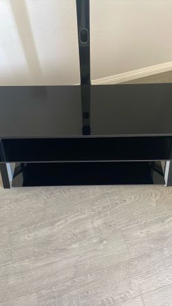 Whalen Furniture Xavier 3-in-1 TV stand featuring a black tempered glass design with silver accents.