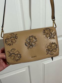 DKNY Paige Floral Leather Flap Crossbody Bag with floral embellishments.