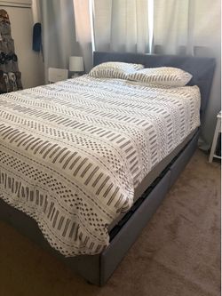 Grey bed frame with four storage drawers