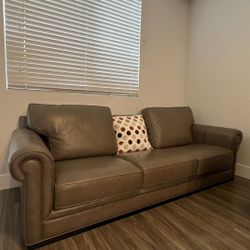 Beautiful genuine leather sofa in a soft taupe tone. Real top-grain leather, plush cushions, and elegant rolled arms. Comfortable and durable, fits pe